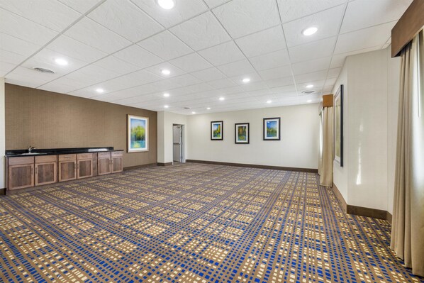 A spacious room with a patterned floor, a kitchenette, and framed pictures on the walls. - Best Western North Bryant Inn San Angelo (San Angelo)