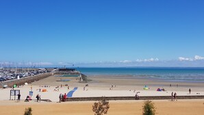 A beach with a marina, sandy shore, and clear blue sky.