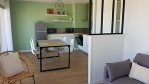 A compact kitchen with a dining area, a refrigerator, microwave, and a small oven.