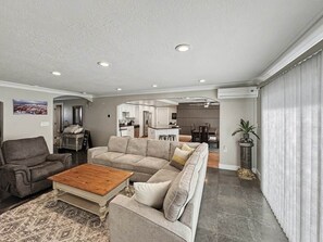 A modern living room with a sectional sofa, a coffee table, and a gray armchair.