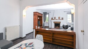 Un salon chaleureux avec une cheminée, un bureau en bois et un globe terrestre.