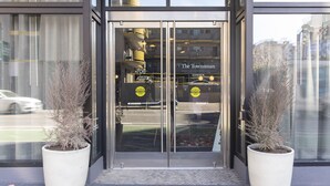 A hotel entrance with a glass door, two potted plants, and a sign reading "The Townsman." - Hotel EPIK (San Francisco)