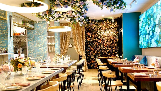 A restaurant with long tables, chairs, and floral decorations. - Hotel EPIK (San Francisco)