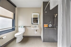 Un bagno moderno con WC, lavandino, specchio, doccia e una finestra.