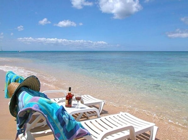 Relax on the beach with comfortable lounge chairs, towels, and a refreshing drink at your fingertips.