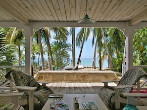 Relax in a tranquil ocean-view setting surrounded by palm trees, with comfortable lounge chairs and a convenient table for your essentials.