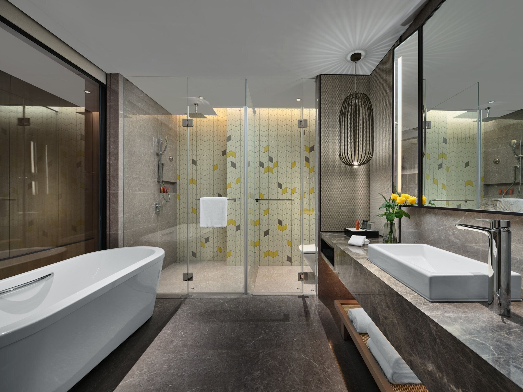 A modern bathroom with two sinks, a shower, and a glass-enclosed shower area.