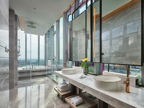 Een moderne badkamer met twee grote wastafels, een grote spiegel en uitzicht op de stad.