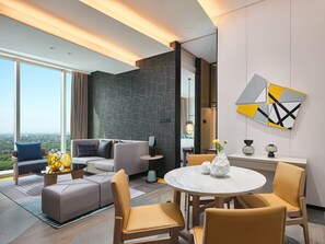 Een moderne hotelkamer met een groot raam, een bank, een eettafel en een decoratieve vaas.