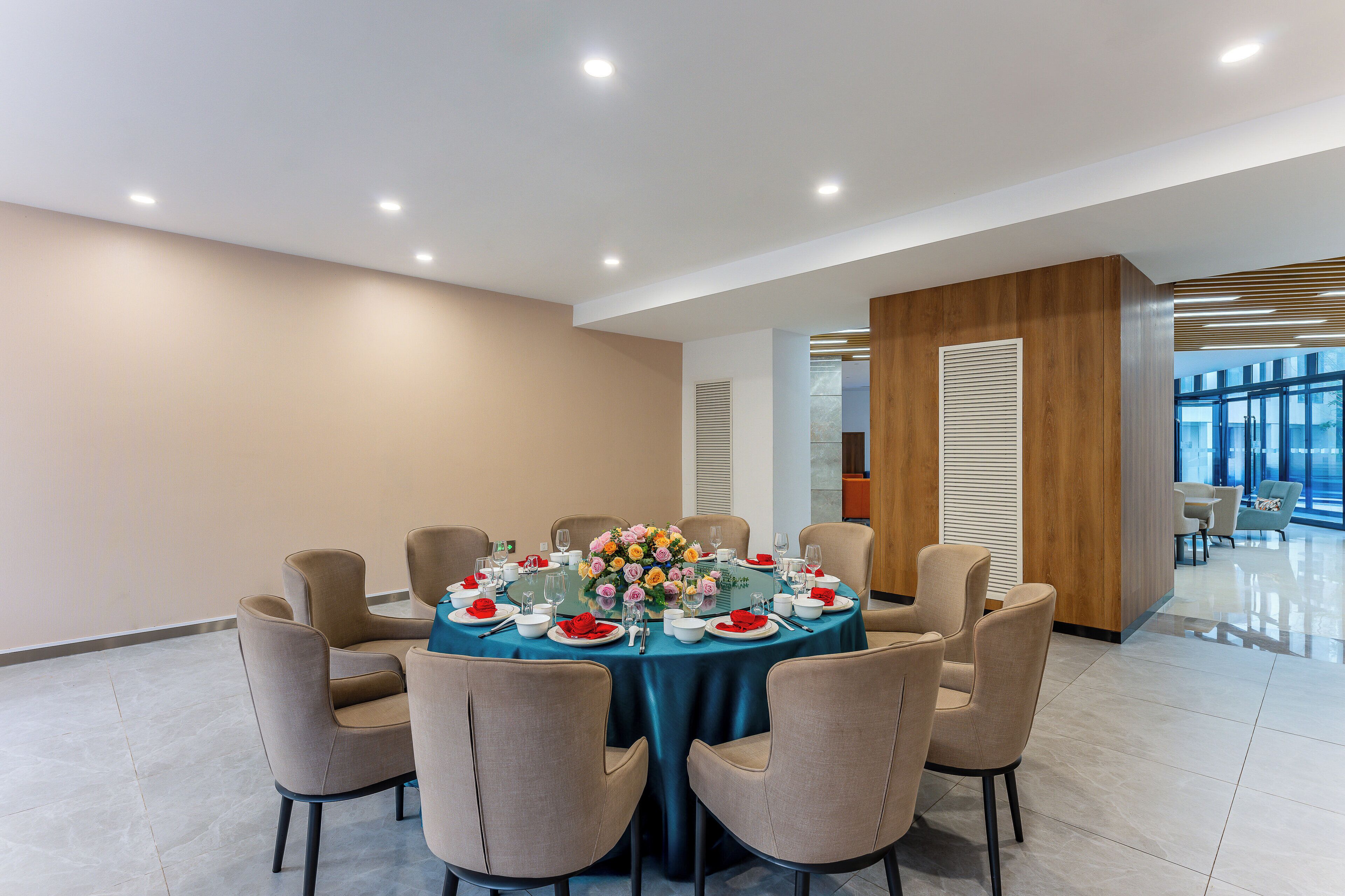 A conference room with a round table set for a meeting, surrounded by chairs.