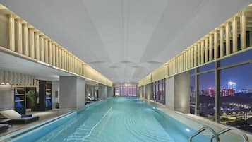 Una piscina techada, sillones reclinables de piscina