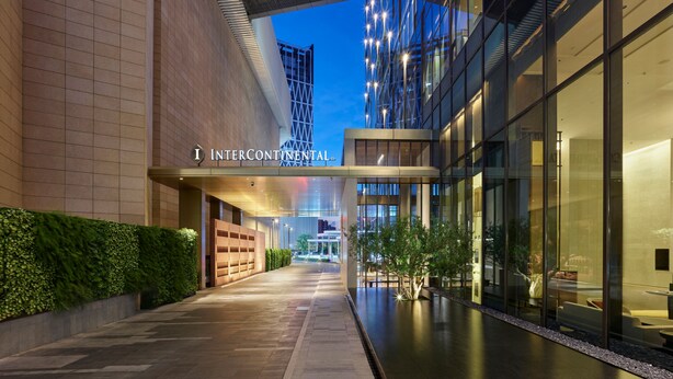 A modern building with a glass facade, a sign reading "INTERCONTINENTAL", and a well-lit interior space. - Intercontinental Dongguan by IHG (Dongguan)