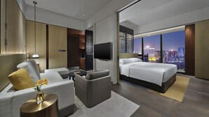 A modern hotel room with a city view, a sofa, a bed, and a TV. - Intercontinental Dongguan by IHG (Dongguan)