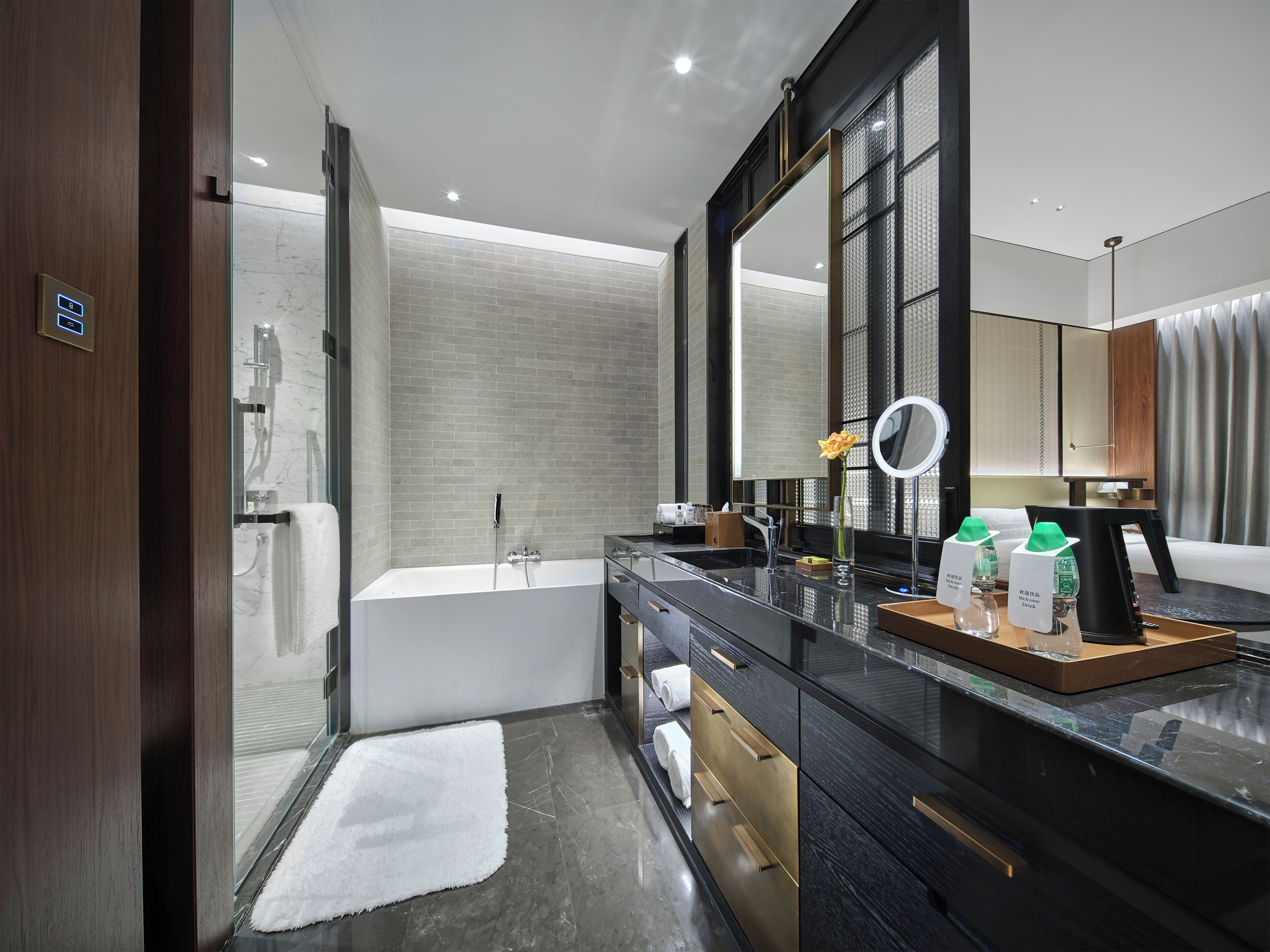 A modern bathroom with a large mirror, a bathtub, and a vanity with a sink.