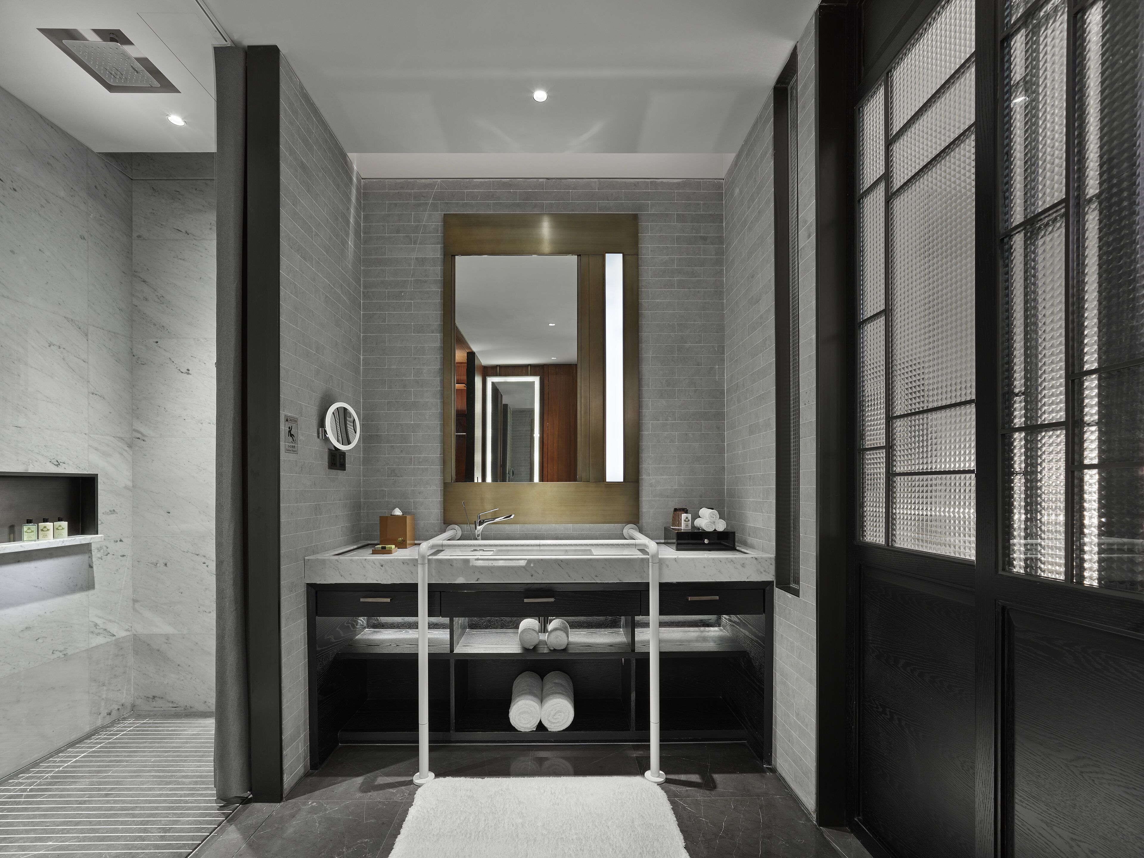 A modern bathroom with a large mirror, dual sinks, and a towel rack.