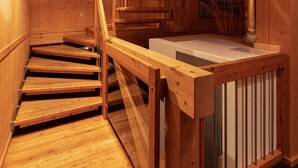 Un interior de madera con una escalera que sube a un nivel superior.