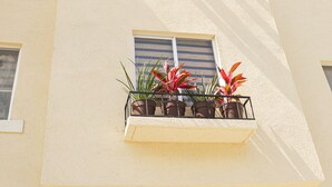 Um edifício com varanda e vasos de plantas.