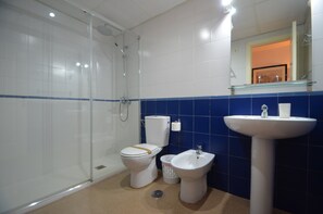 Ein Badezimmer mit Duschkabine, Toilette, Bidet und Waschbecken.