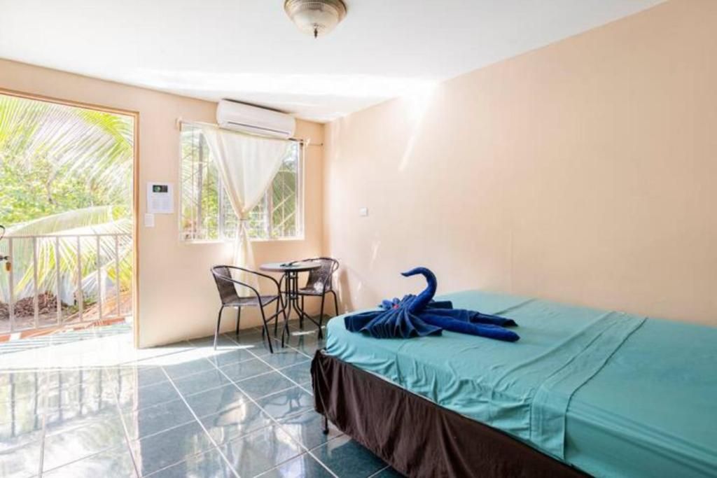 A hotel room with a bed, a small table, and a chair.