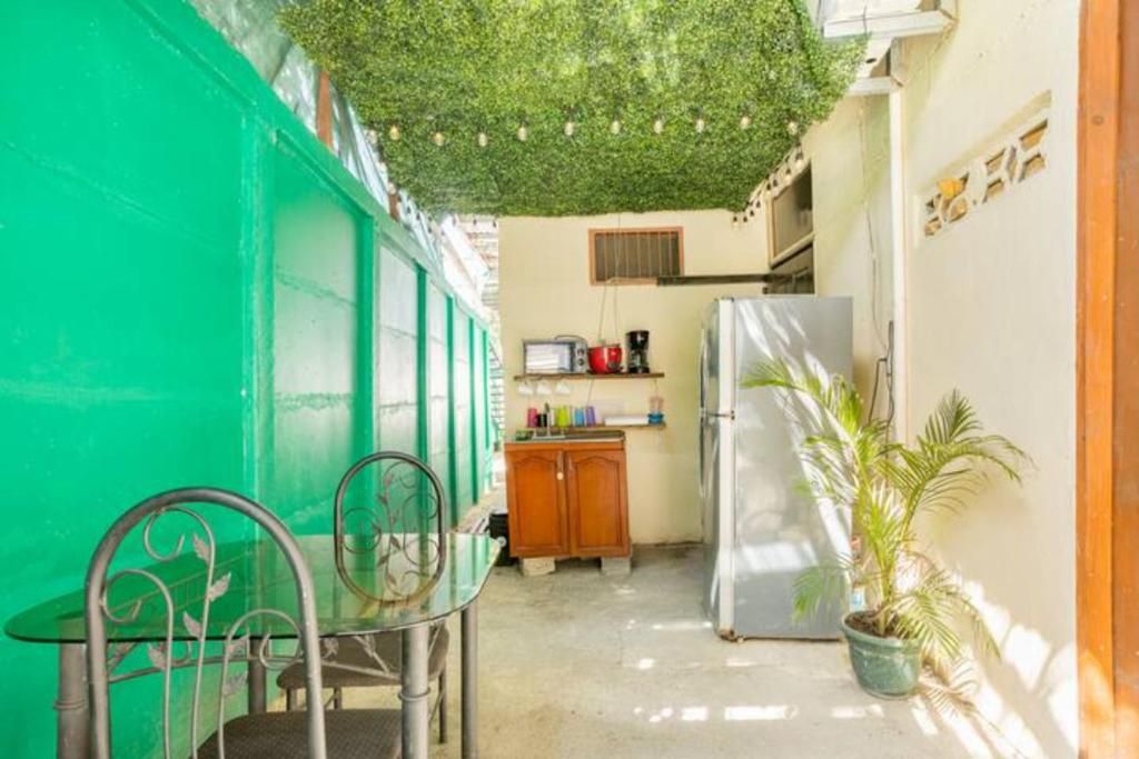 A compact kitchen with a refrigerator, a wooden cabinet, and a small table with chairs.