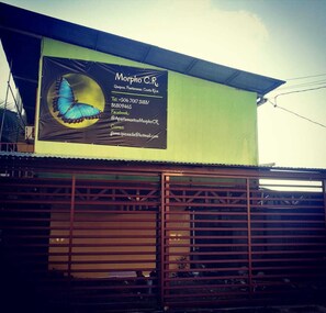 A building with a large billboard advertising 'Morpho C.R.' apartments in Puntarenas, Costa Rica.