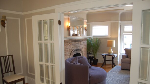 A living room with a fireplace, a large window, and a seating area.