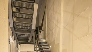 A modern staircase with metal railings and a tiled floor, leading to an upper level. - Hotel Boutique Maria (Morelia)