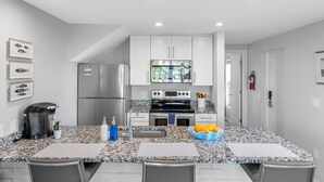 A modern kitchen with white cabinets, stainless steel appliances, and a granite countertop. - 3 Bedroom/3 Bath Townhouse - Unit 3 (Nokomis)