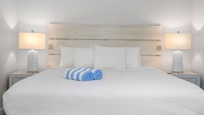 A neatly made bed with white bedding and two pillows, flanked by two bedside tables with lamps and decorative vases. - 3 Bedroom/3 Bath Townhouse - Unit 3 (Nokomis)