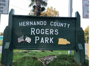 Welcome to Hernando County Rogers Park, featuring a sign with the park's name and American flags.