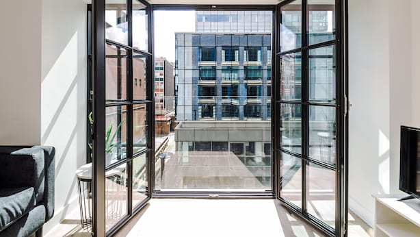 A modern apartment with a large glass door leading to a balcony. - Hilltop Serviced Apartments - Piccadilly (Manchester)