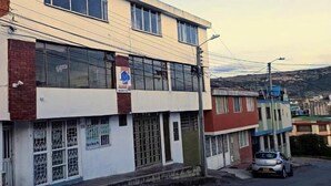 Un edificio de varios pisos con fachada plana, ventanas grandes y un letrero visible en la planta baja.