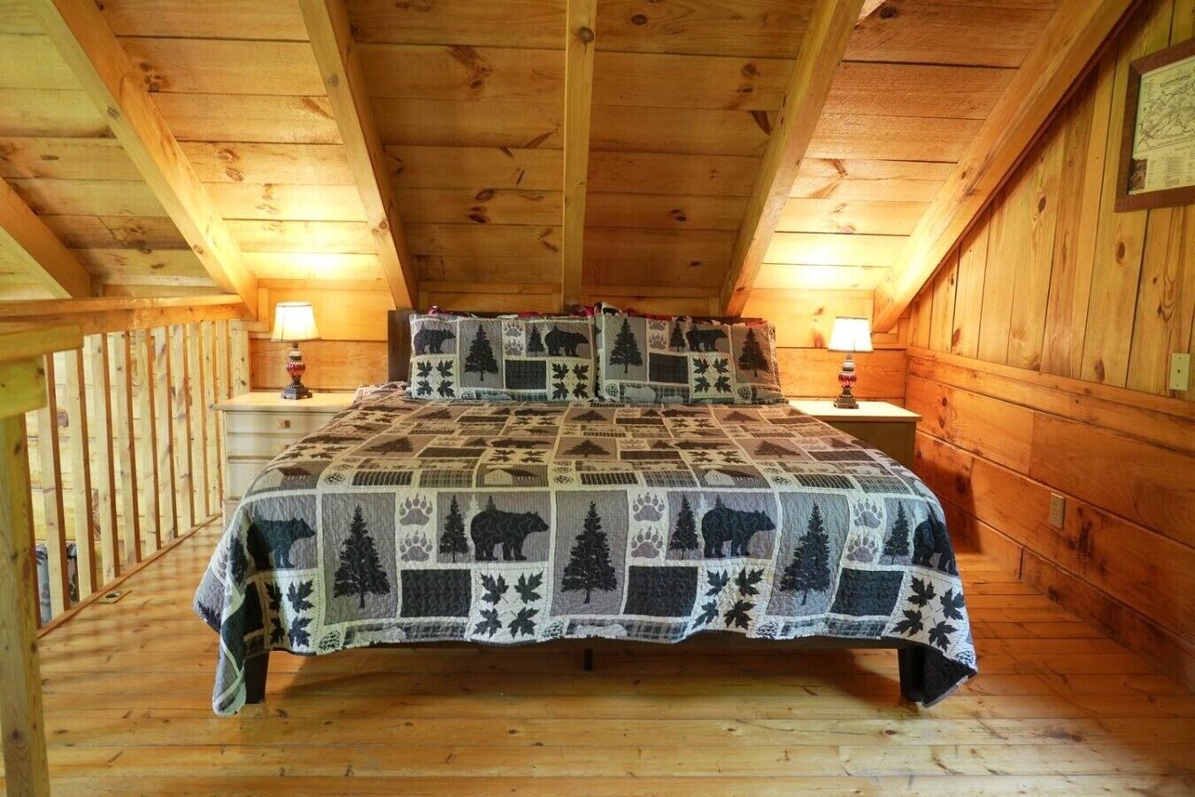 Ein Schlafzimmer einer Holzhütte mit einem Bett, zwei Nachttischen und einer Holzbalkendecke.