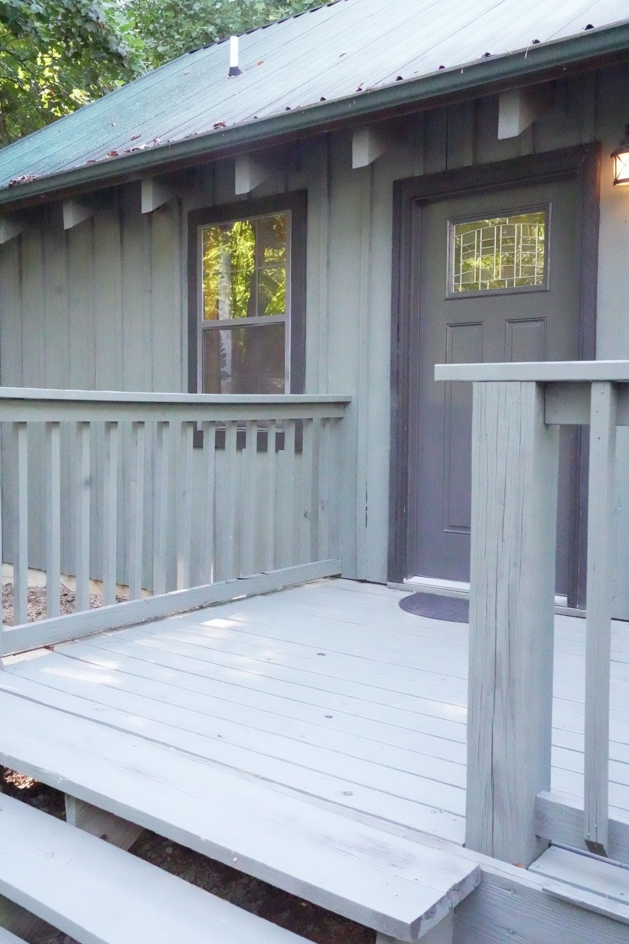 A building with a porch, two windows, and a door.
