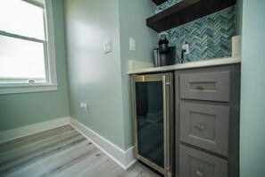A kitchen with a built-in refrigerator, a coffee maker, and a herringbone tile backsplash. - Upscale Beach Front Home w/Elevator, Private Pool, Fire Pit! (Cape San Blas)