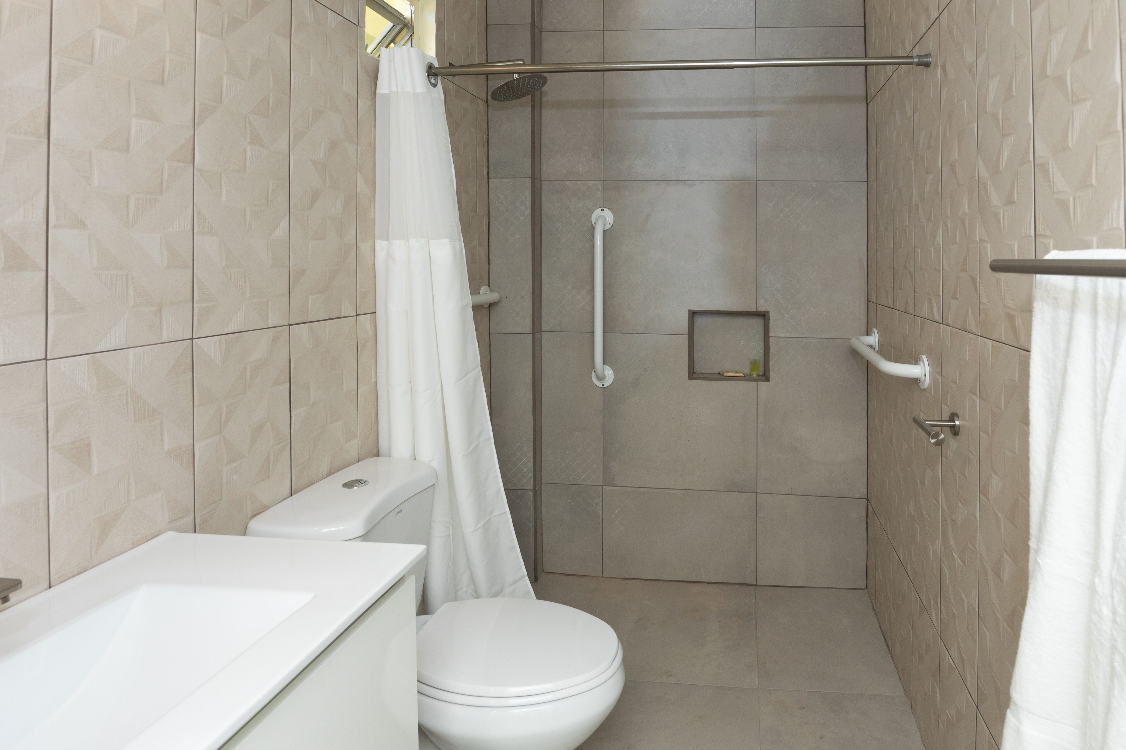 A modern bathroom with a shower, toilet, and sink.