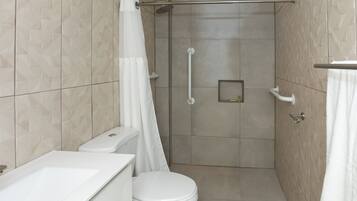 A modern bathroom with a shower, toilet, and sink.