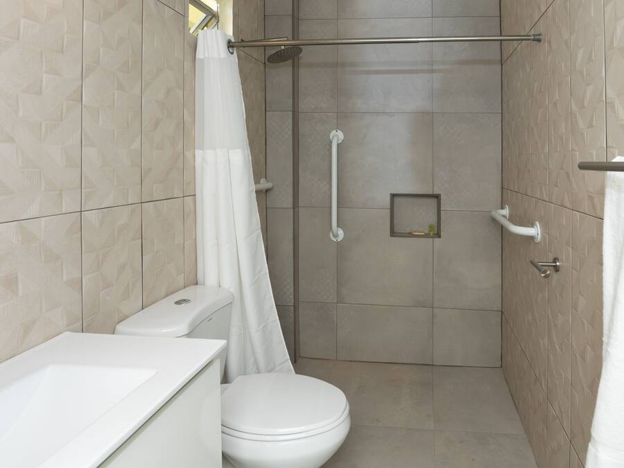 A modern bathroom with a shower, toilet, and sink.