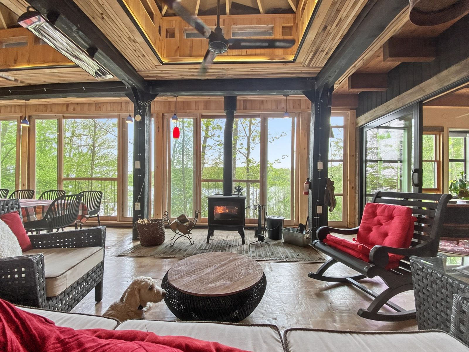 A spacious room with a fireplace, large windows, and a ceiling fan.