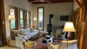 A cozy living room with a sofa, armchairs, a coffee table, and a fireplace.