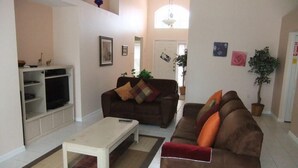 Un salon avec deux canapés, une table basse et un meuble pour la télévision.