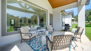 An outdoor patio with a table and chairs, a grill, and a view of the surrounding landscape. - 'Cascada at Canyon Lake' ~ 1 Mi to Wedding Venues! (Spring Branch)