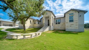 A modern two-story house with a stone facade, a covered driveway, and a well-maintained lawn. - 'Cascada at Canyon Lake' ~ 1 Mi to Wedding Venues! (Spring Branch)