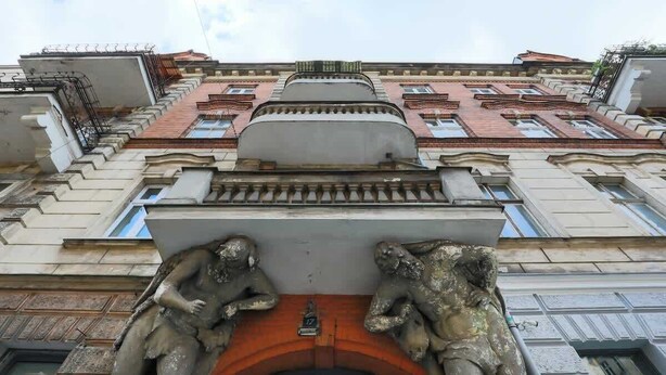 A building facade with classical architectural elements, including statues and a central archway. - Stylish Studio | Next to Wilson Park and MTP Fair. (Poznan)