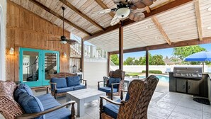 An outdoor covered patio with wicker furniture, a ceiling fan, and a barbecue grill. - Southern Jewel  - Vacation Home Near the Beach with Private Pool & Outdoor Space (Destin)