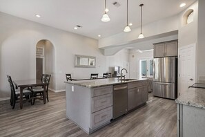 Enjoy cooking in this well-equipped kitchen with a large island, sink, and ample counter space.
