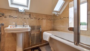 A bathroom with a sink, towel rack, and bathtub.