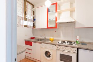 Cocina compacta con lavadora, estufa y lavaplatos.