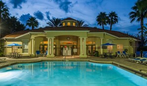 A hotel with a swimming pool, outdoor seating, and palm trees. - Luxury Lake View 3 bedroom in resort community. Disney 3 miles (Kissimmee)