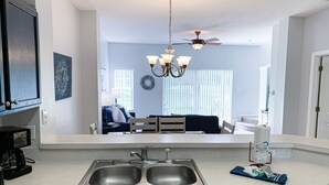 A modern kitchen with a double sink, a dishwasher, and a ceiling fan. - Luxury Lake View 3 bedroom in resort community. Disney 3 miles (Kissimmee)